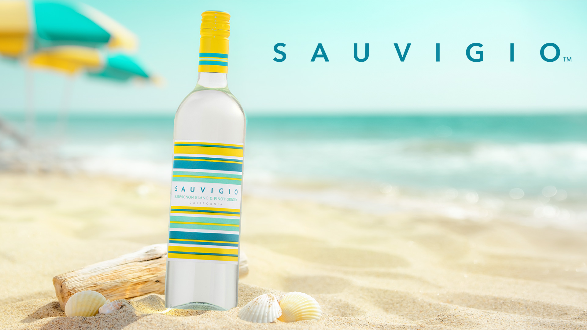 A bottle of Sauvigio wine on a white sand beach with an ocean background and the Sauvigio logo
